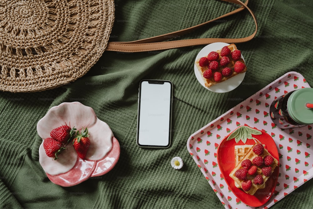 a table topped with plates of food and a phone