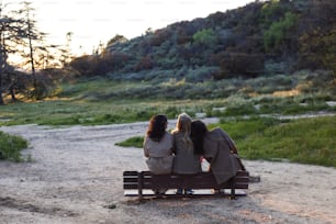 Drei Frauen sitzen auf einer Bank in einem Park