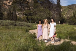 Un grupo de tres mujeres de pie una al lado de la otra en un campo