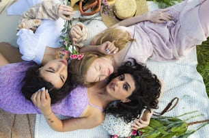 a group of young women laying on top of a grass covered field