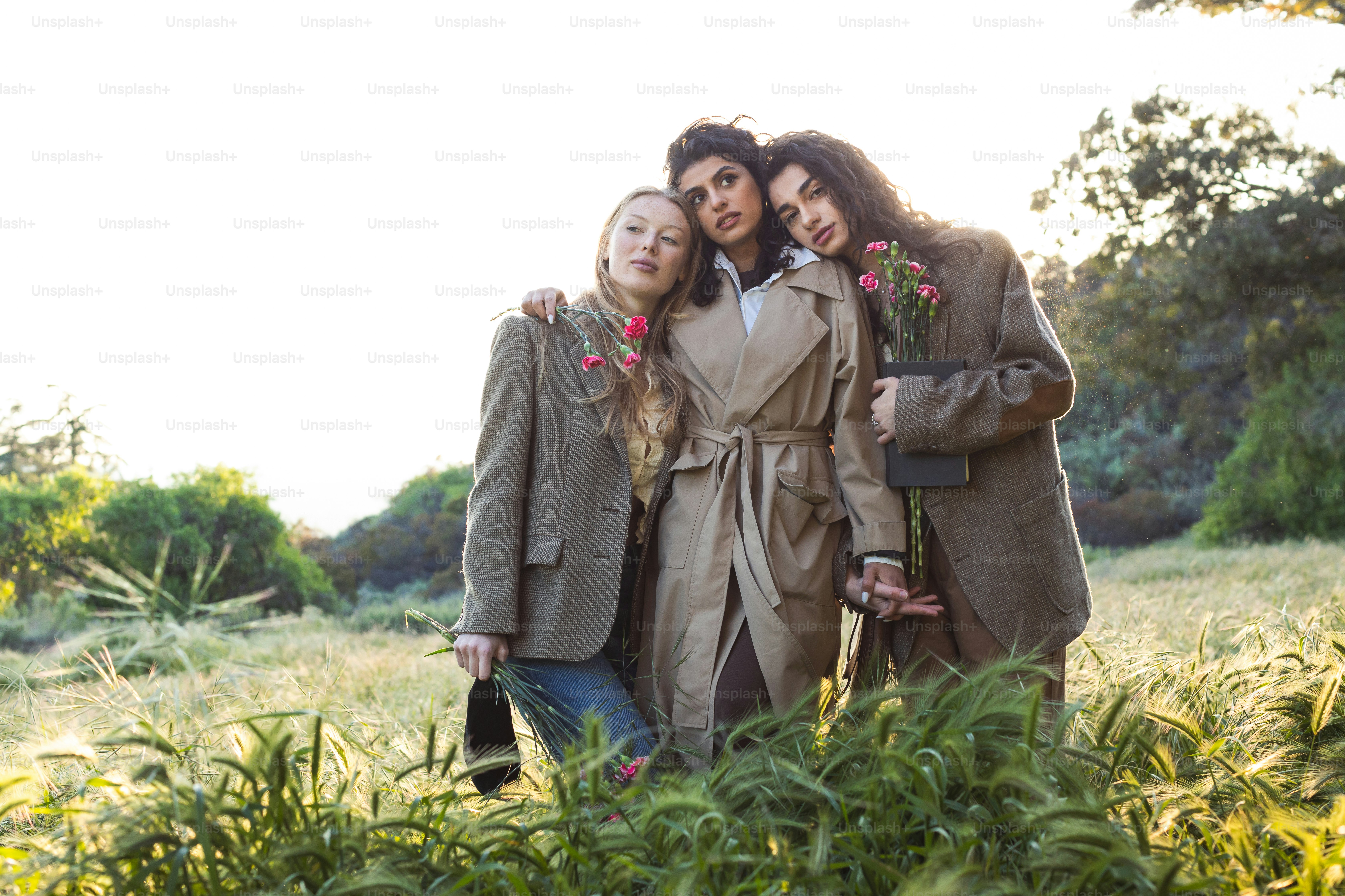 A group of three women standing next to each other photo – Fashion ...