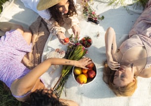 a group of women laying on top of a grass covered field