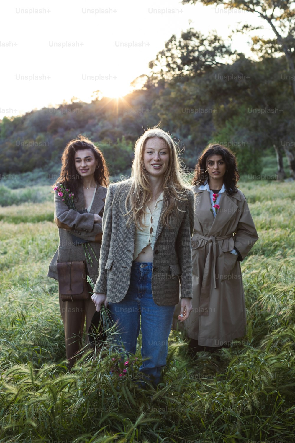 Drei Frauen stehen auf einem Feld mit hohem Gras
