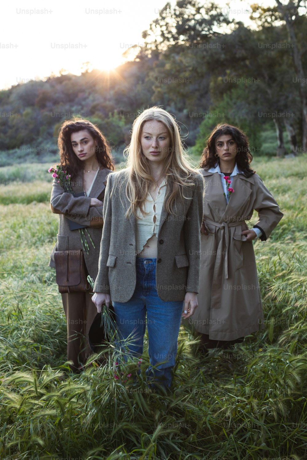 three women standing in a field of tall grass