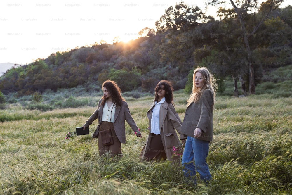 a group of women walking through a lush green field