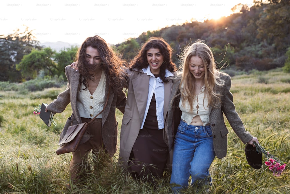 a group of three people walking through a field