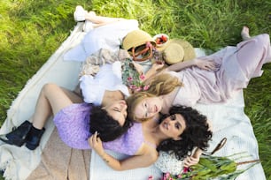 a group of women laying on top of a grass covered field