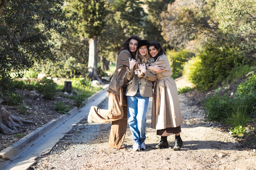 a group of women standing next to each other on a dirt road