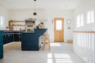 una cucina con armadi blu e un piano di lavoro bianco