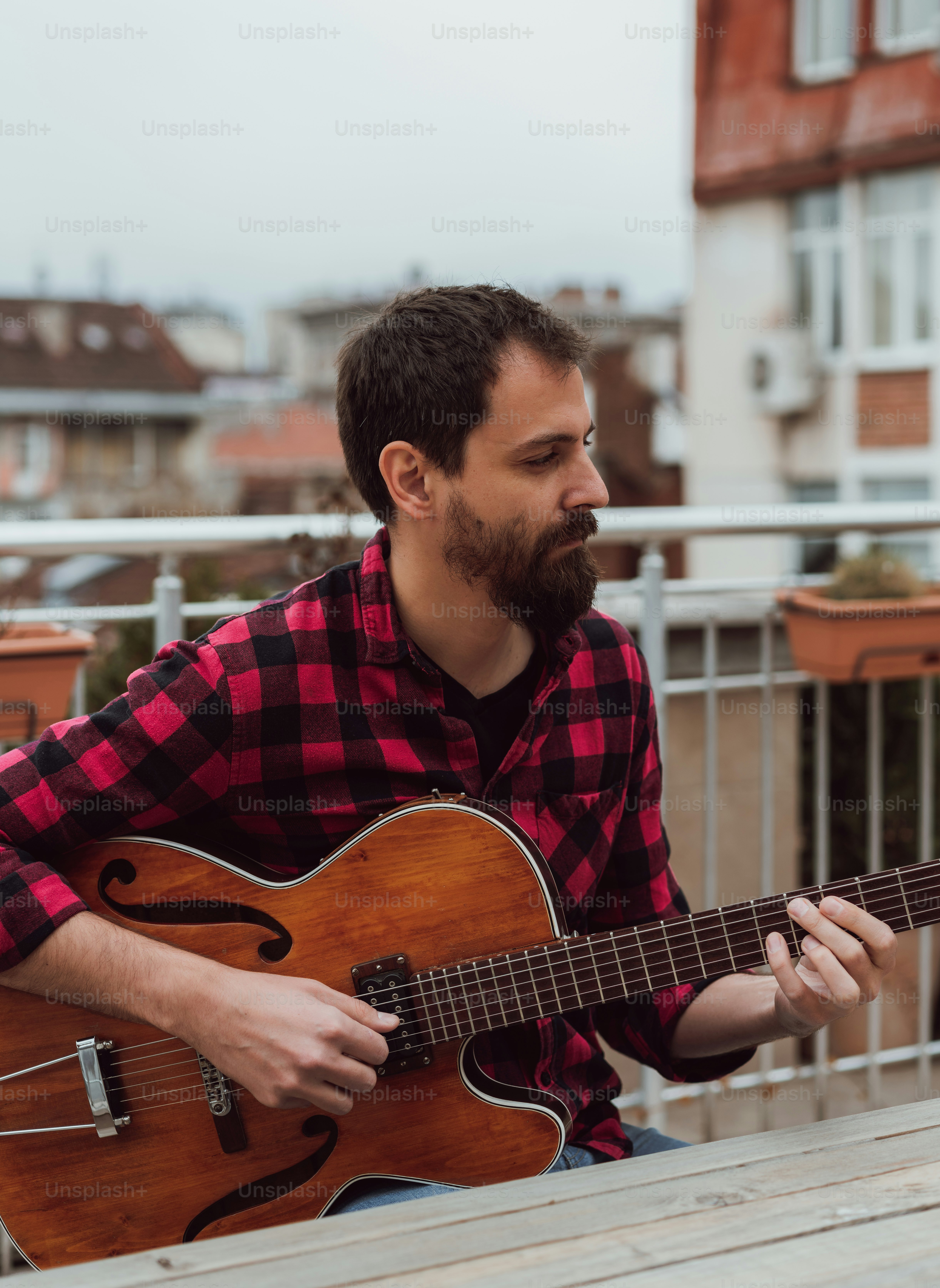 a man sitting on a bench playing a guitar