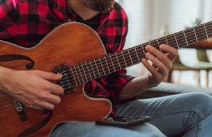 Un uomo seduto su un divano che suona una chitarra