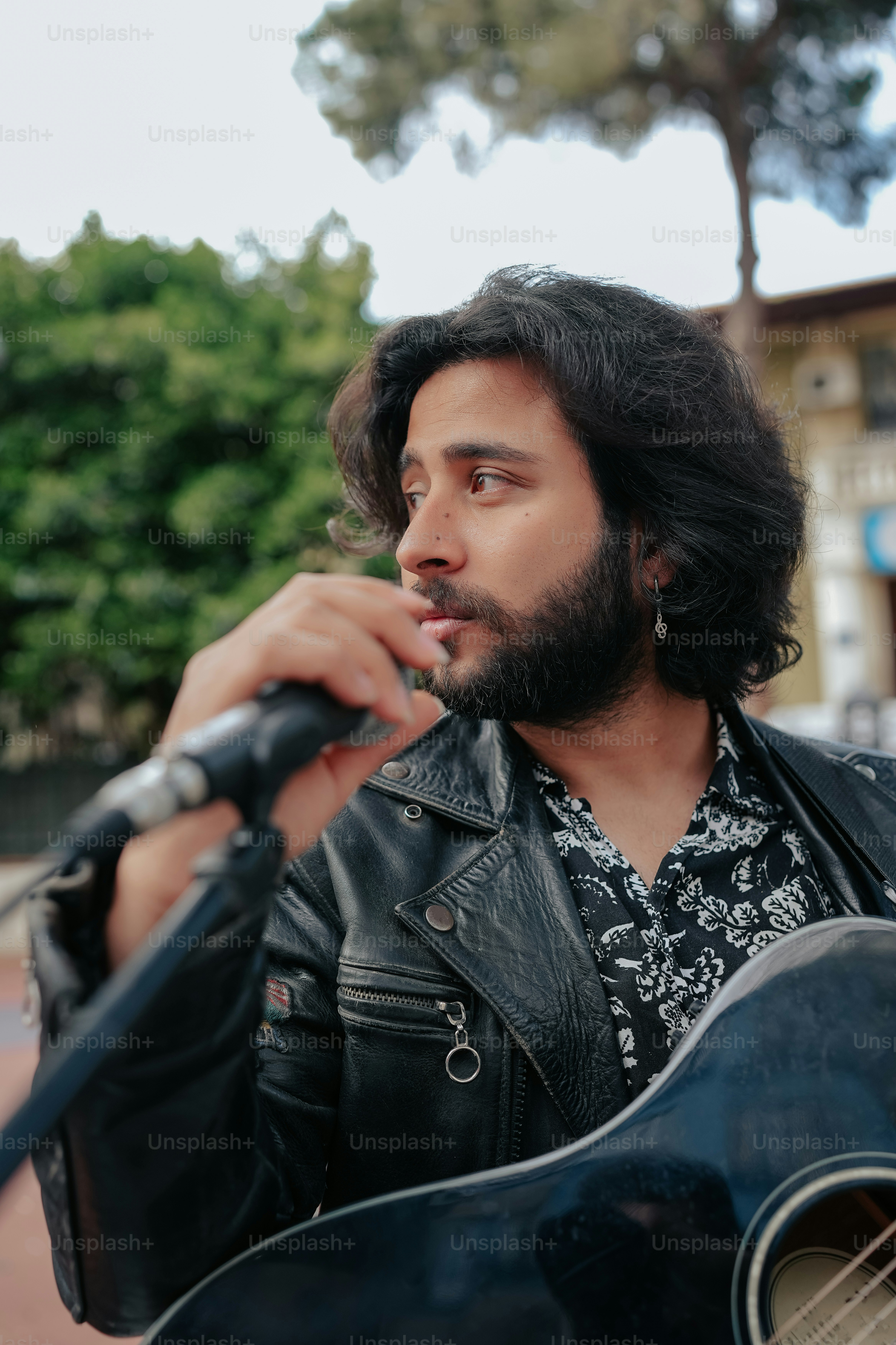 a man with a beard holding a guitar