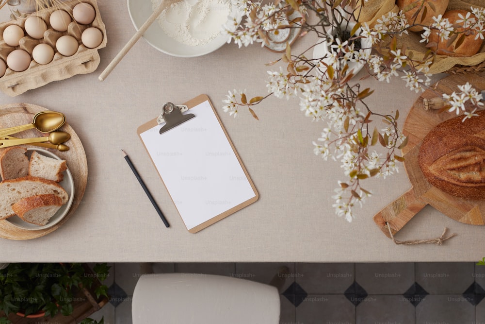 a table topped with a clipboard next to a plate of bread