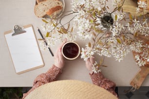 a person sitting at a table with a cup of coffee