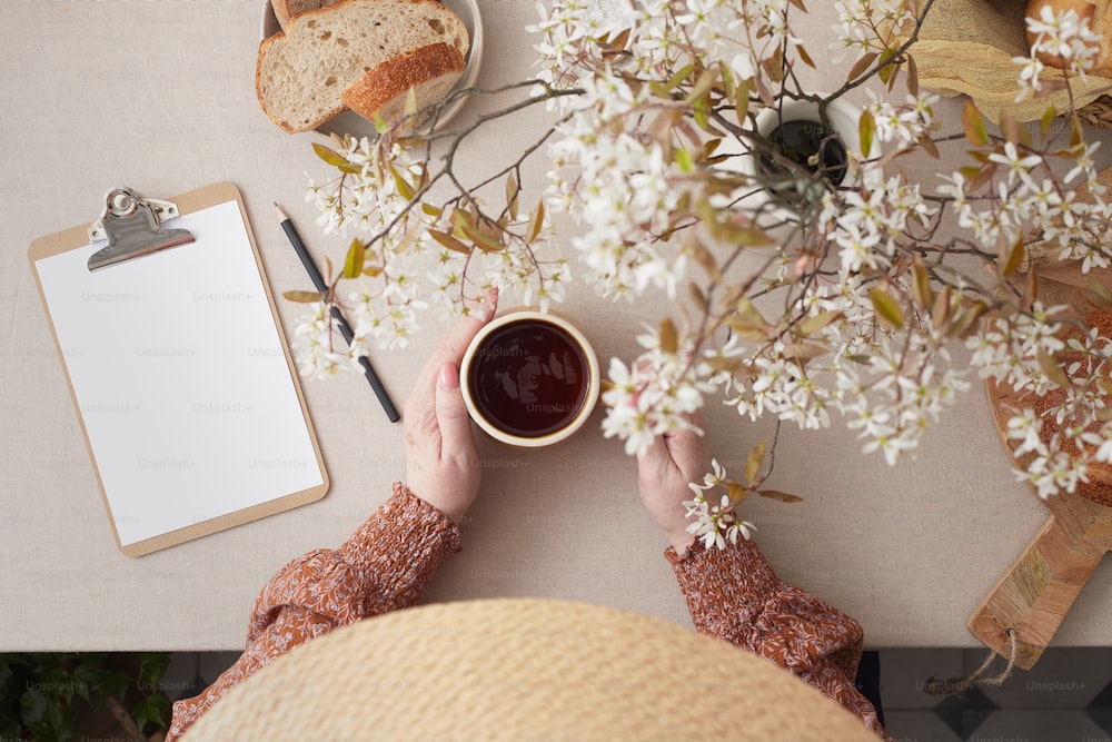 a person sitting at a table with a cup of coffee