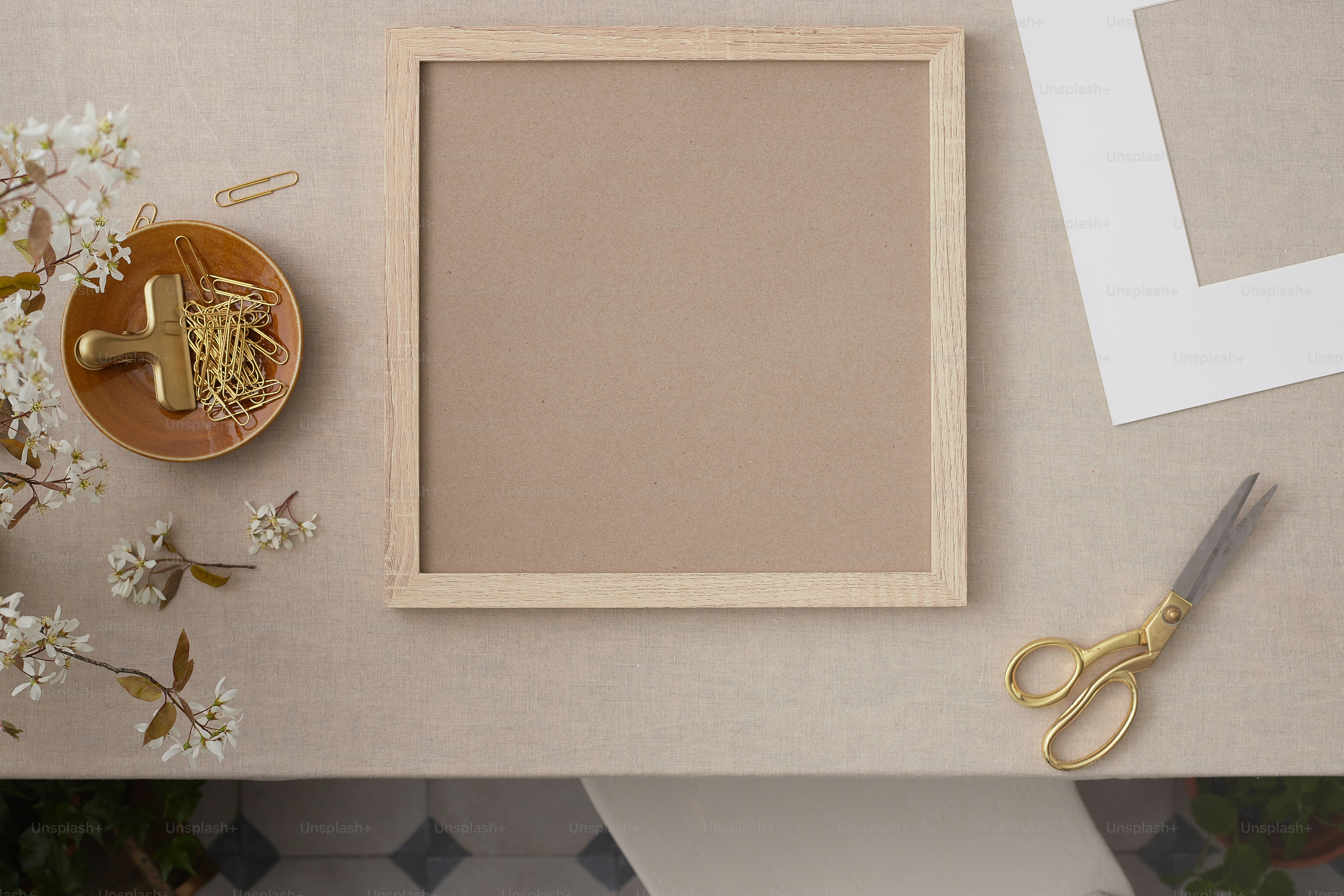 un marco de fotos, tijeras y flores sobre una mesa