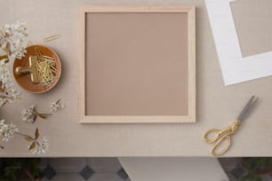 a picture frame, scissors, and flowers on a table