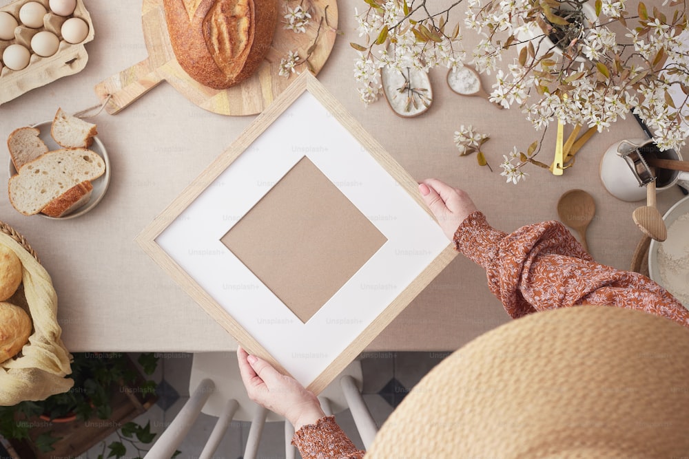 a person holding a picture frame in front of a table full of food