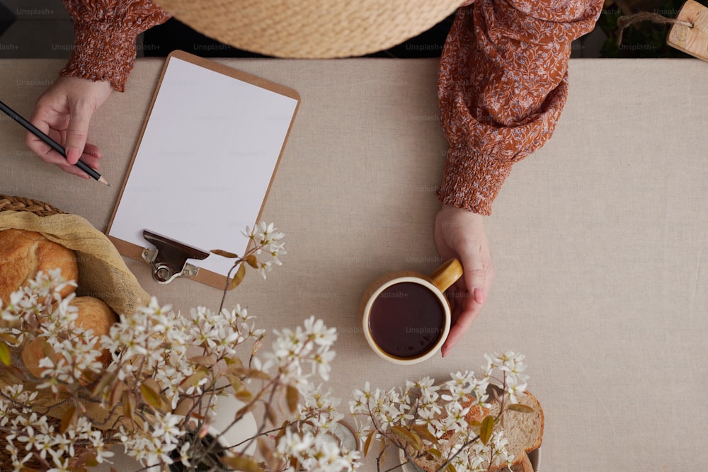 a person sitting at a table with a cup of coffee