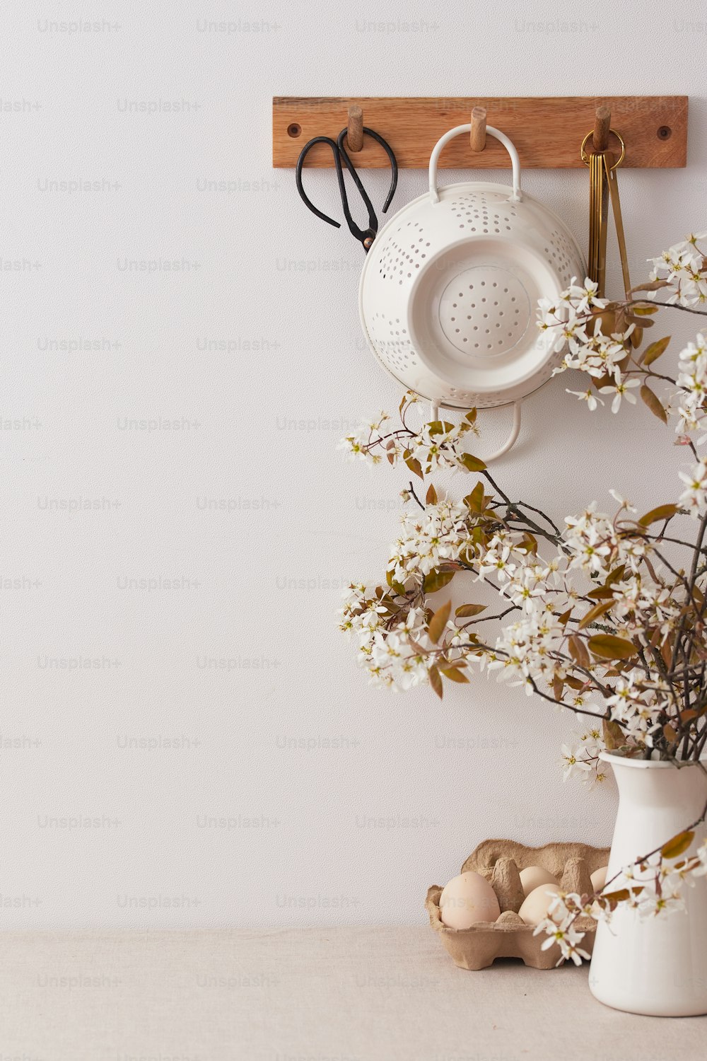 eine weiße Vase mit Blumen und eine Schere