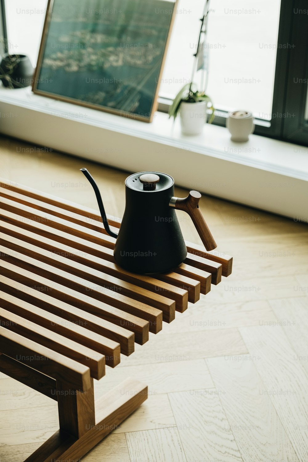 a coffee pot sitting on top of a wooden bench