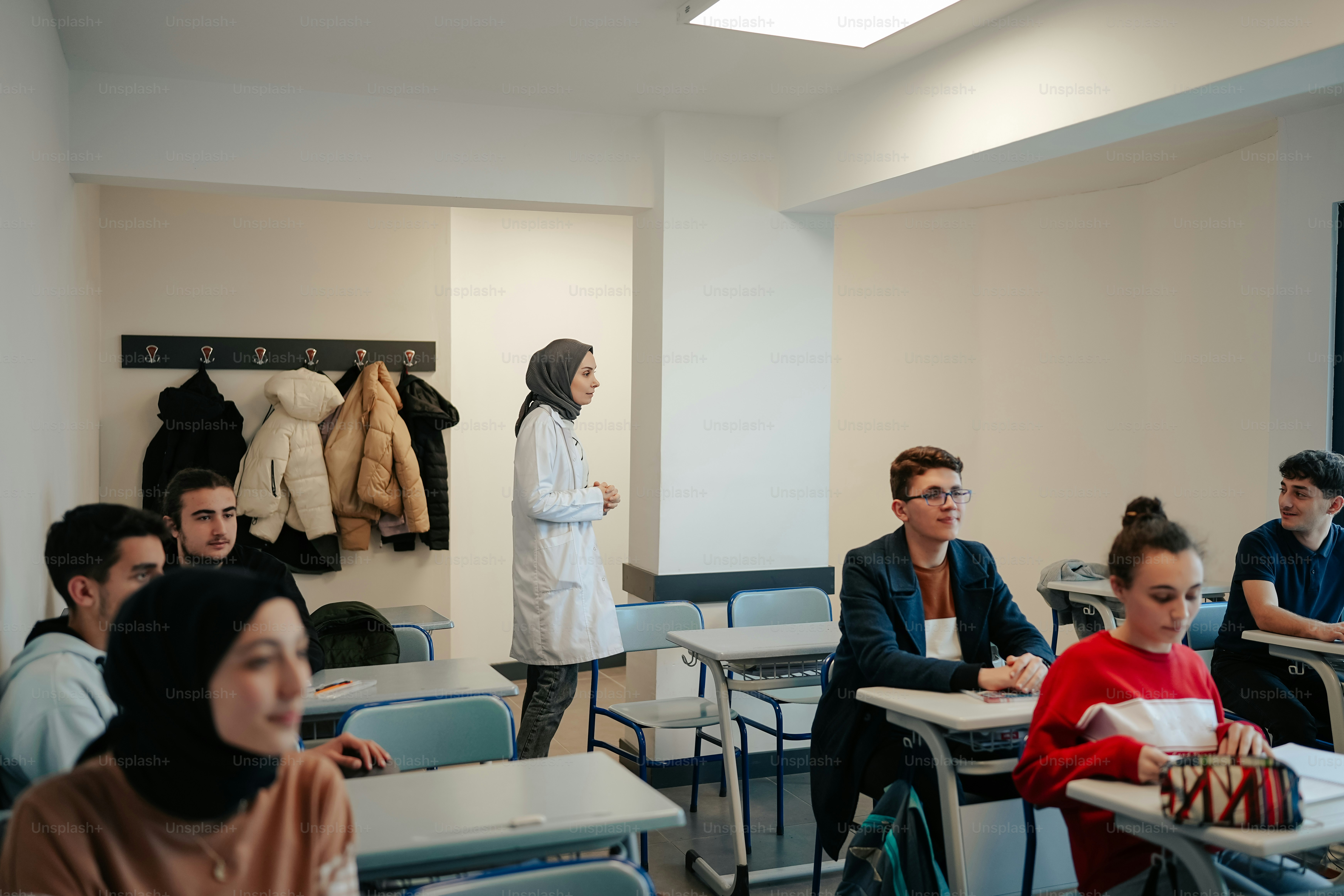 a group of people sitting at desks in a classroom