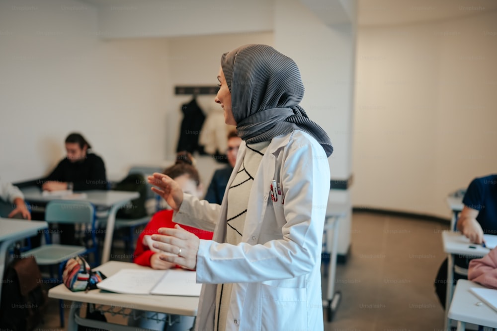 Eine Frau mit Hijab steht in einem Klassenzimmer
