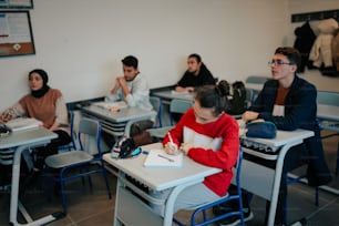 um grupo de pessoas sentadas em carteiras em uma sala de aula