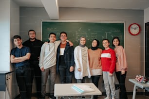 a group of people standing in front of a blackboard