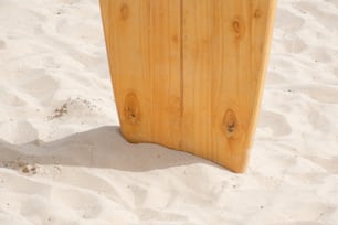 a surfboard sticking out of the sand on a beach