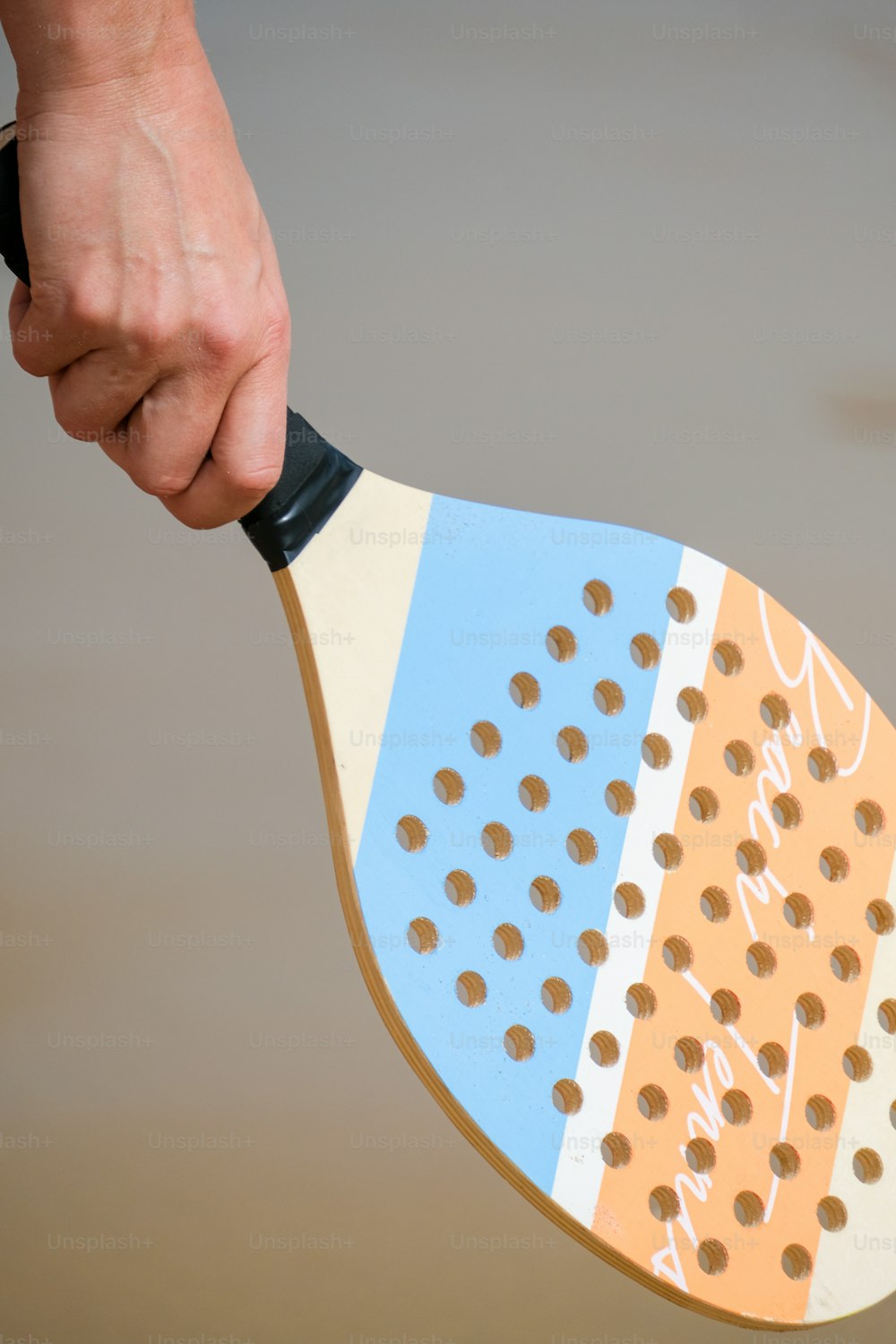 um close up de uma pessoa segurando uma raquete