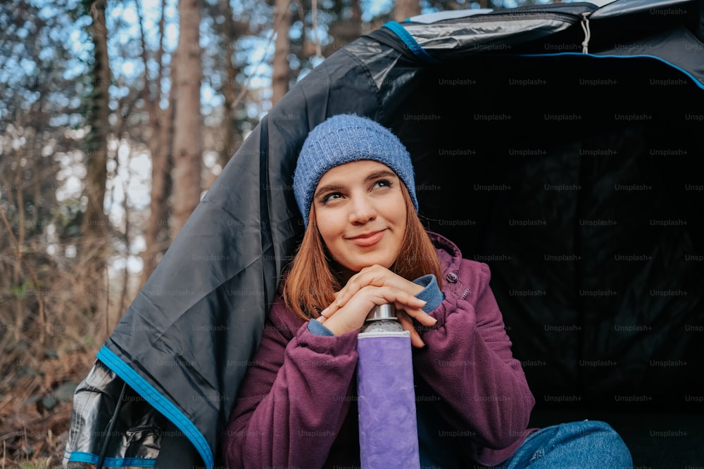 a woman sitting in a tent with a purple tie