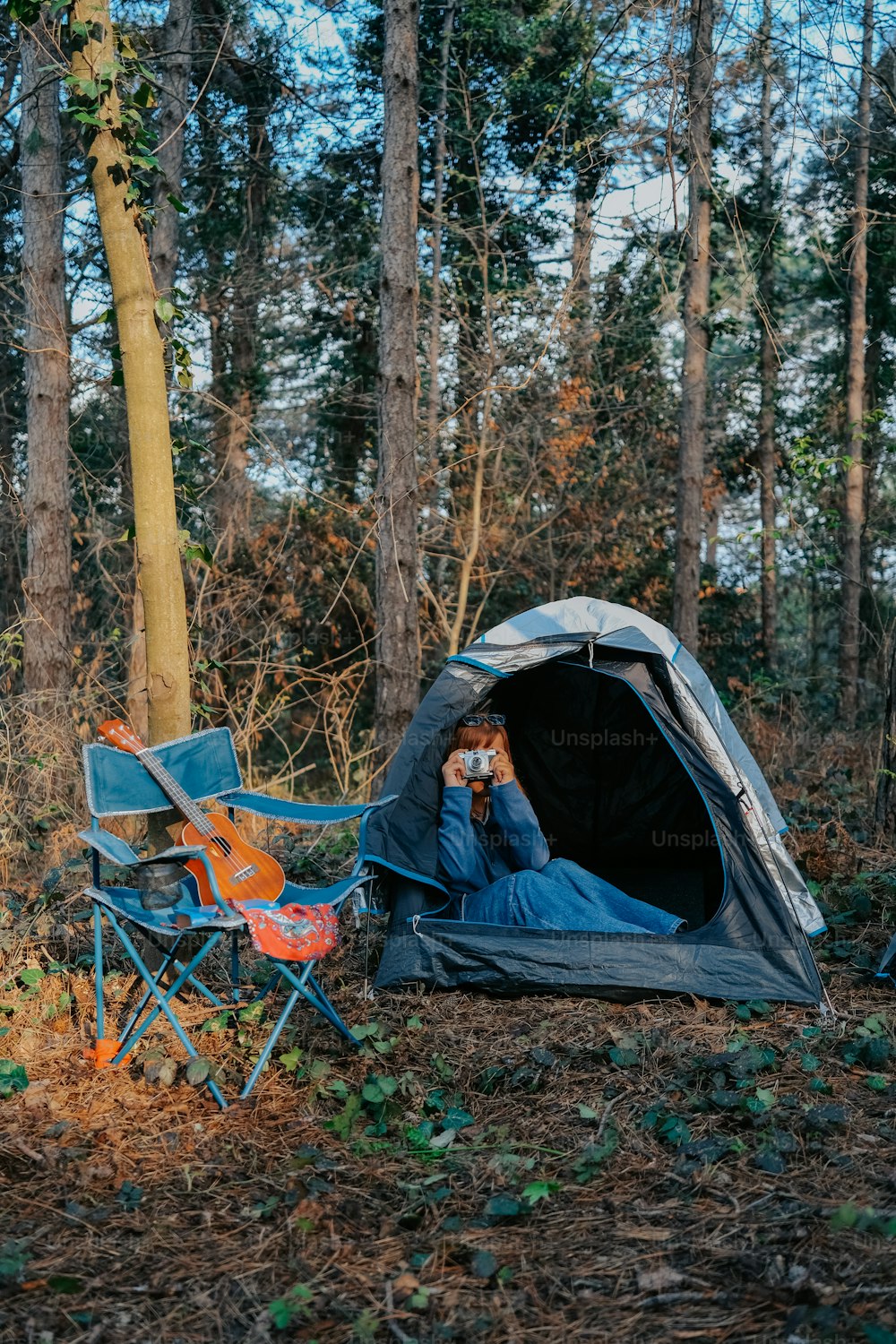 a person sitting in a tent in the woods