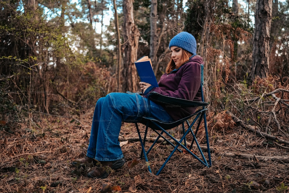 a woman sitting in a chair reading a book