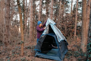 a person putting up a tent in the woods