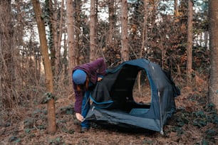 a person putting up a tent in the woods