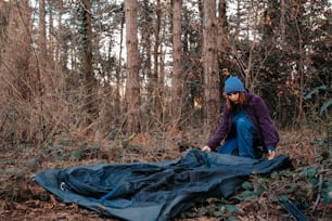 a person in the woods with a tarp on the ground