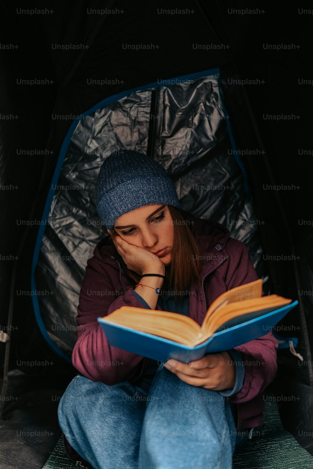 텐트에 앉아 책을 읽고 있는 여자