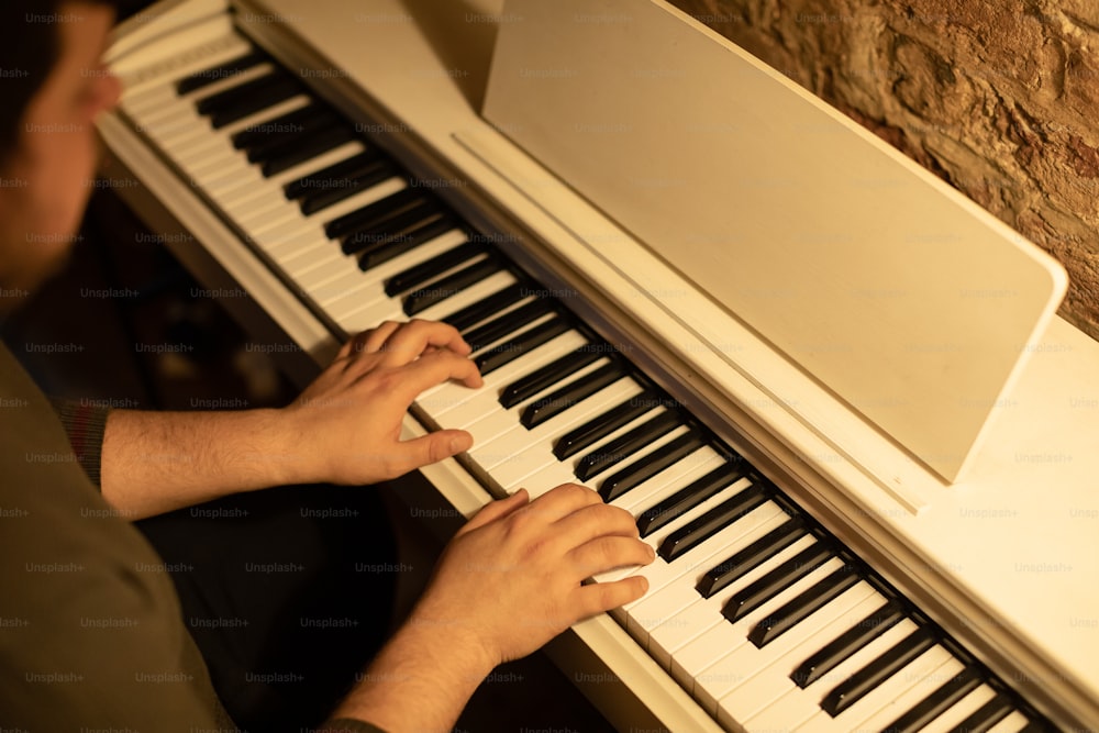 uma pessoa tocando um piano com as mãos