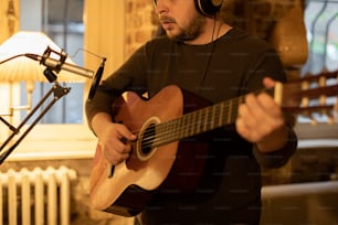 Un hombre con auriculares tocando una guitarra