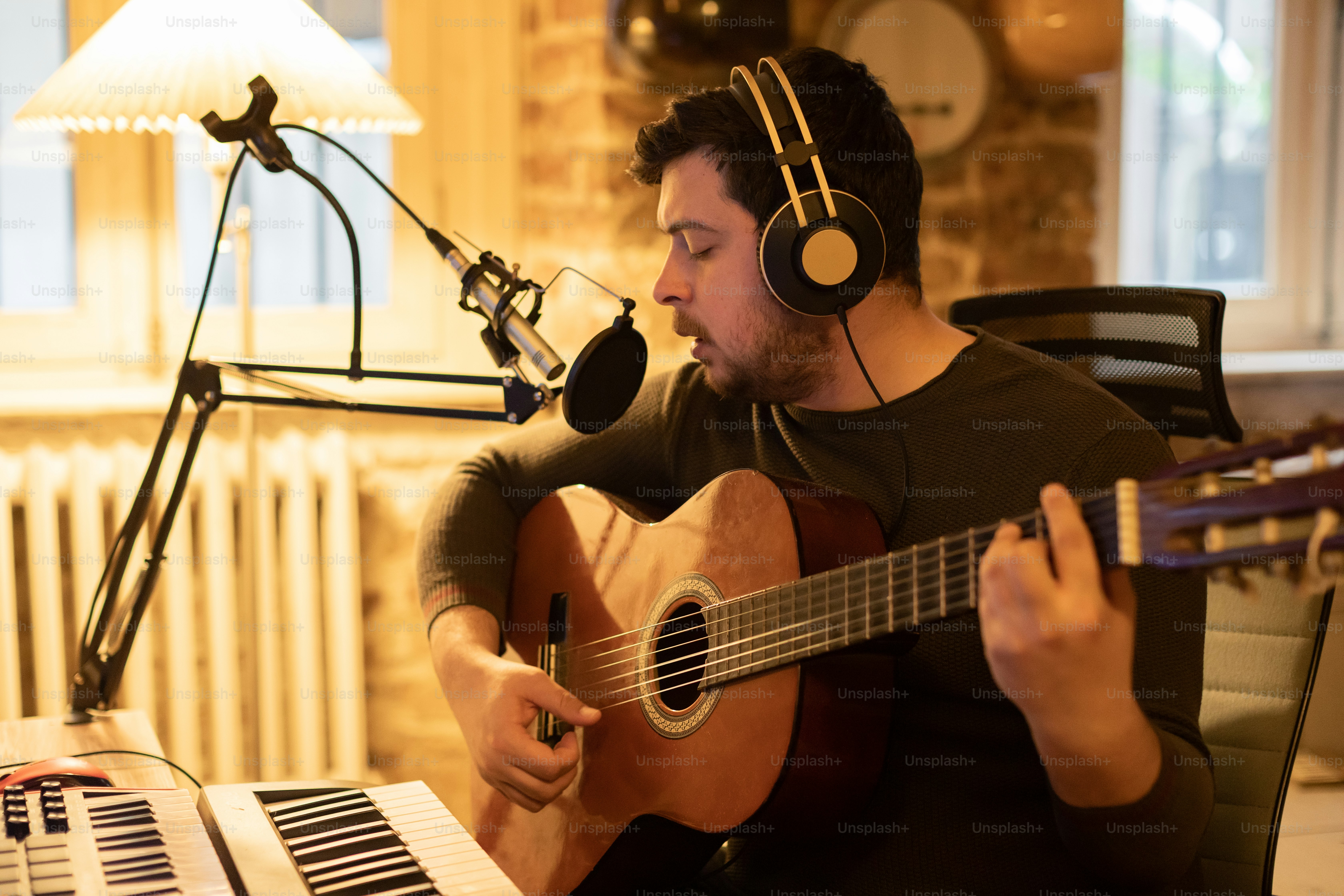 a man sitting in a chair with a guitar and headphones on