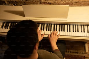 a man is playing a piano in a room