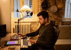 Ein Mann sitzt an einem Schreibtisch und spielt Keyboard