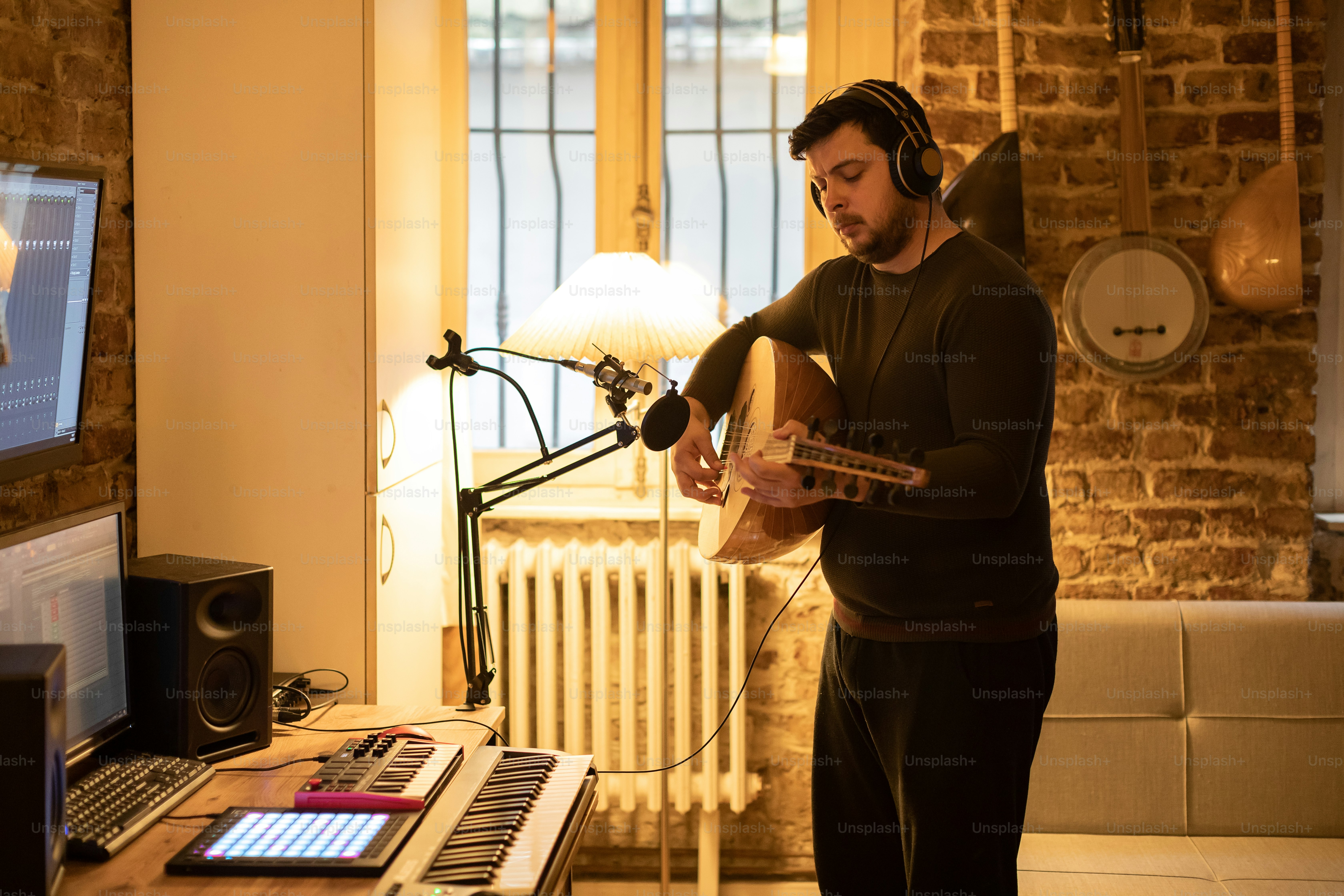 a man playing a guitar in front of a microphone
