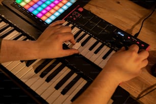 a person playing a keyboard with a colorful light on it