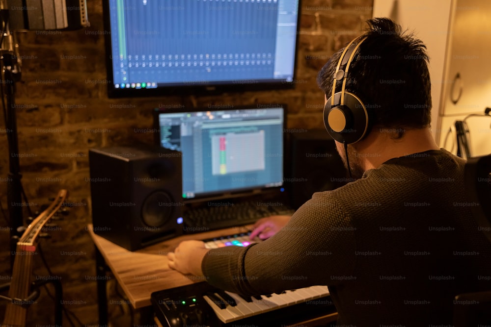 a man wearing headphones sitting in front of a computer