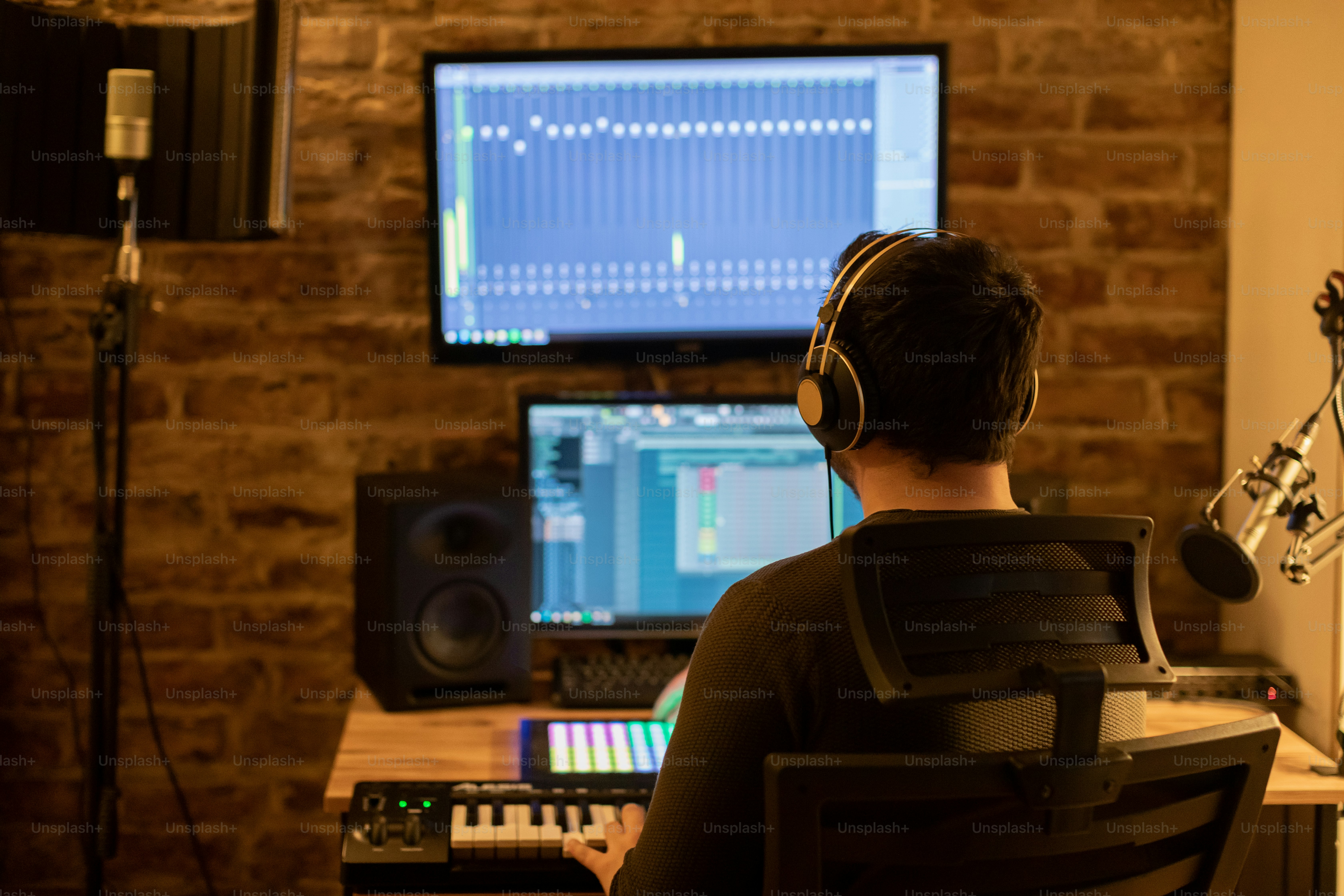 a man sitting in front of a computer with headphones on