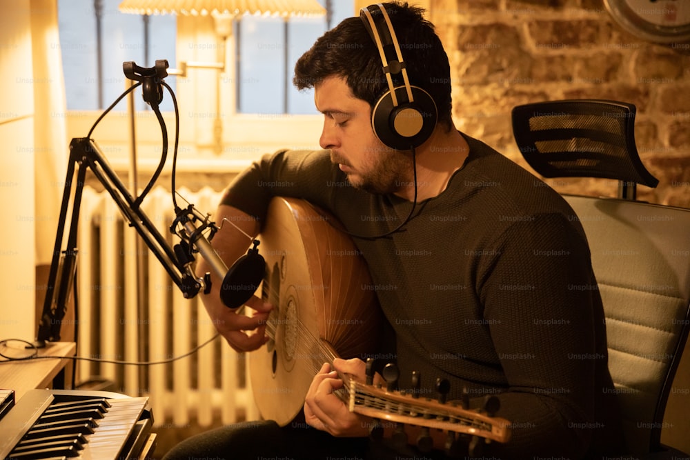 a man sitting in front of a microphone with headphones on