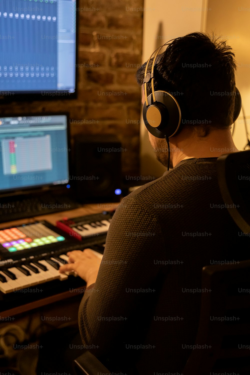 a man wearing headphones sitting in front of a computer