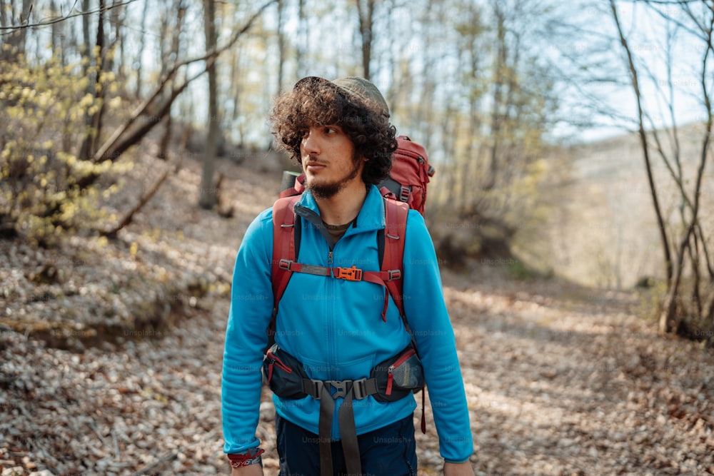 Ein Mann mit einem Rucksack geht im Wald spazieren